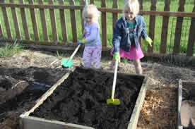 Jackie and Jillian smooth the soil